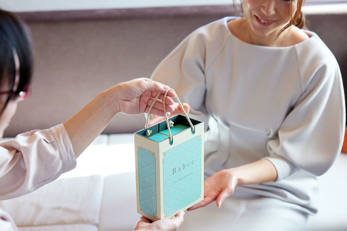 ラステシャンプー＆トリートメント オリジナルギフトパッケージをプレゼントする女性